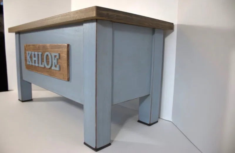 Angled view of the blue Khloe stand showing the distressed paint along the legs and the stained top edge
